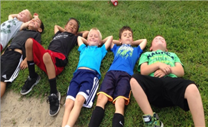 Camp kids laying on the grass